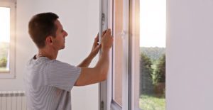 Mann monterer nye vinduer i hus